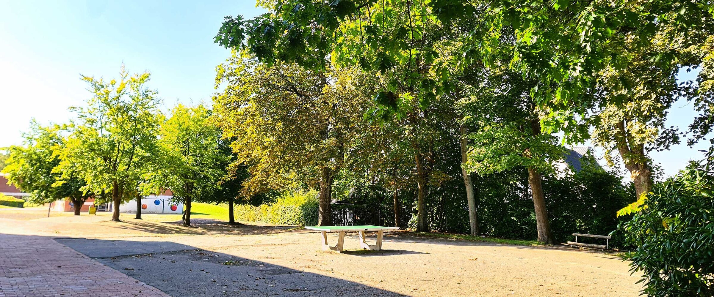 Hier sieht man den Schulhof mit Tischtennisplatten und Fußballtorwand.