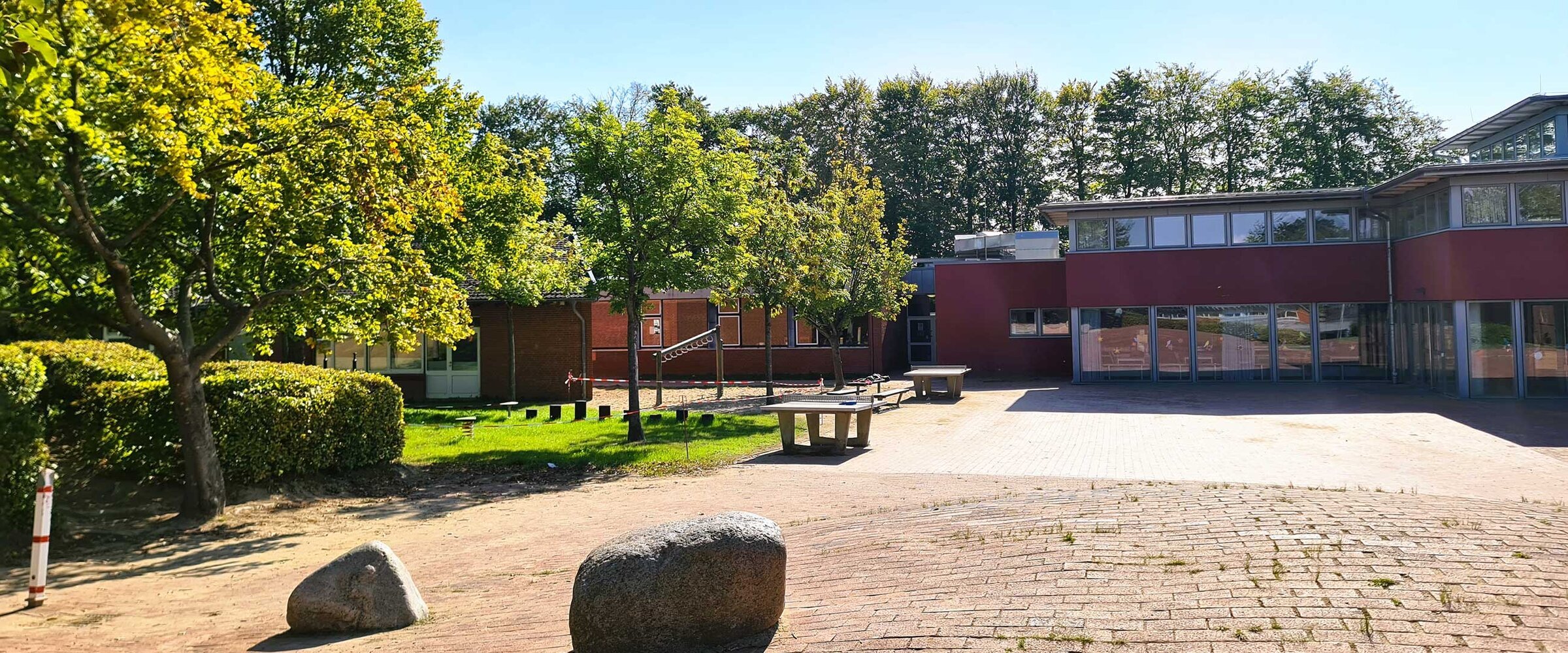 Hier sieht man den Schulhof vor dem Grundschulhaus mit der Mensahalle.